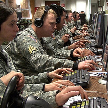 A row of US Army servicemen and women typing at computers